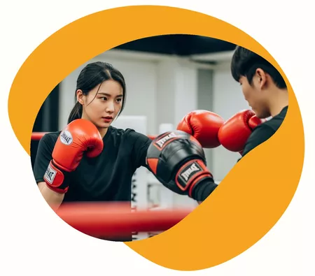 Professeure qui accompagne son élève durant un cours à domicile de boxe